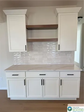 a view with white cabinets and a wooden floor