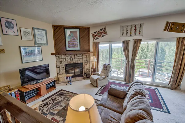 a living room with furniture fireplace and a large window