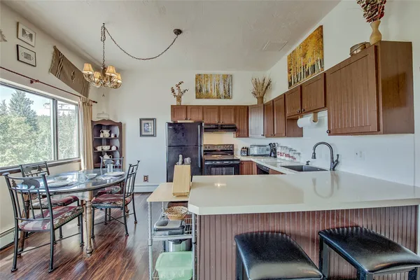 a kitchen with stainless steel appliances a table chairs and a refrigerator