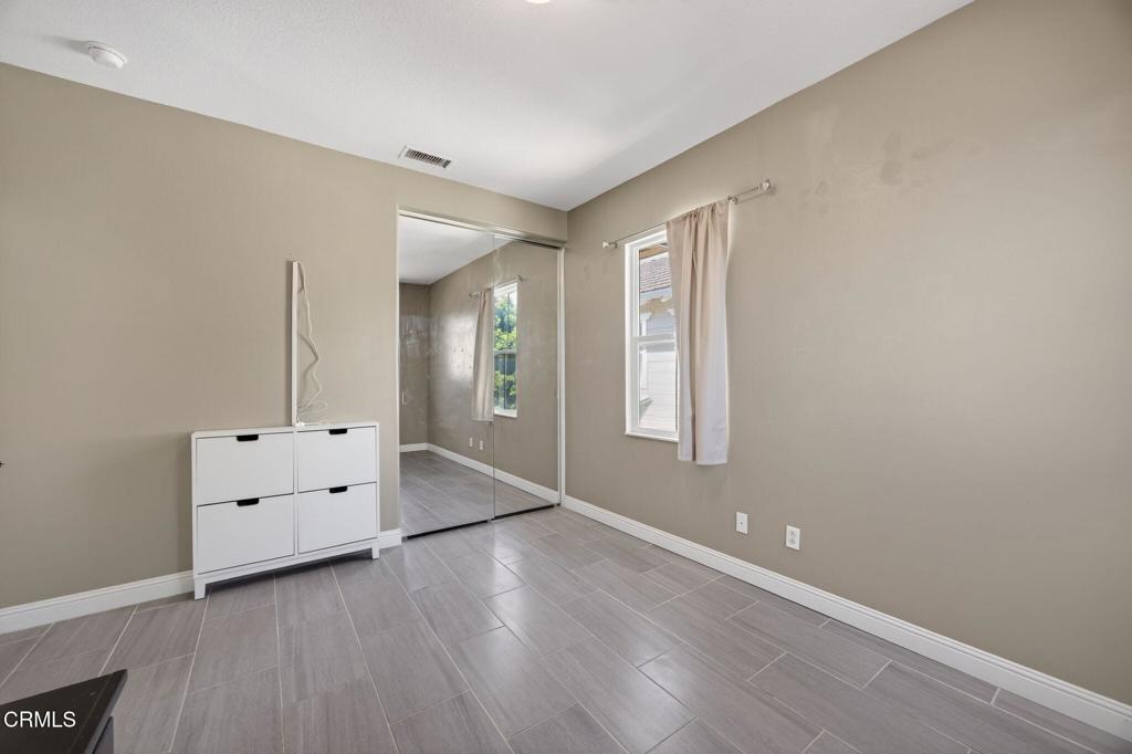5331 Davidson Drive Oxnard, CA 93033 - Photo 22 of 38 an empty room with wooden floor and windows