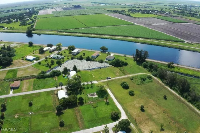 an aerial view of a residential houses with outdoor space and lake view