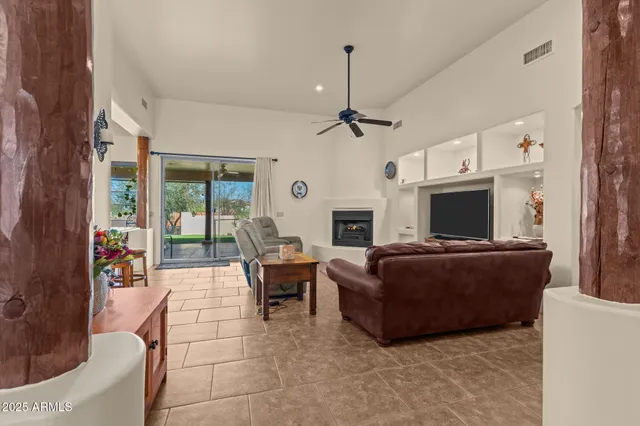 a living room with furniture a flat screen tv and a fireplace