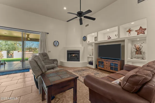 a living room with furniture a flat screen tv and a fireplace