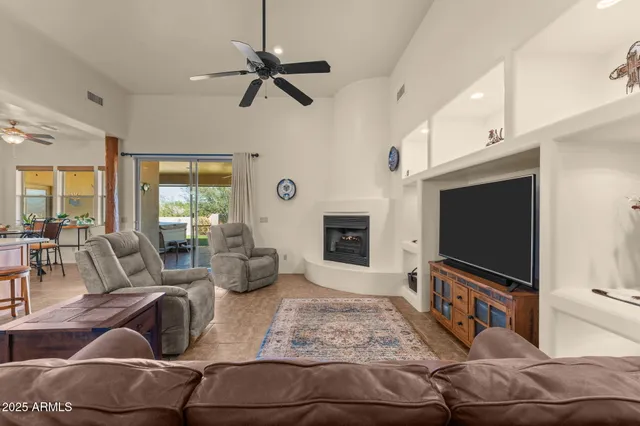 a living room with furniture a flat screen tv and a fireplace