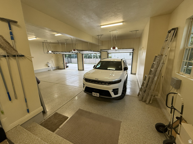 650 East Center Street Alpine, UT 84004 - Photo 37 of 38 Spacious garage featuring a durable epoxy floor coating, multiple overhead garage doors, and ample space