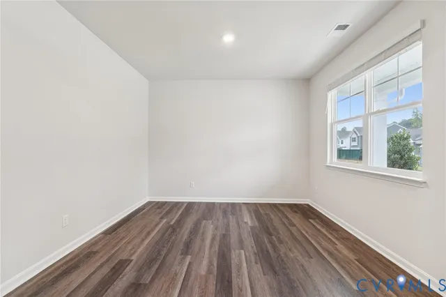 a view of room with window and wooden floor