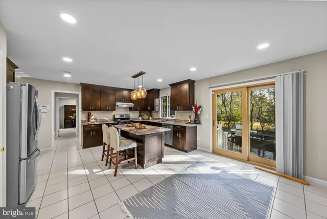 a kitchen with a sink and chairs