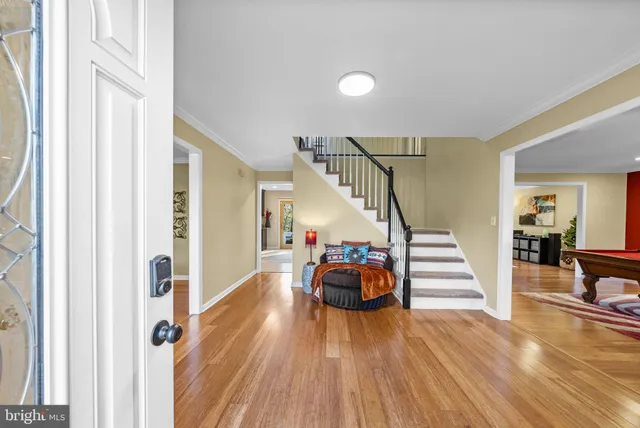 a view of a livingroom with wooden floor and stairs