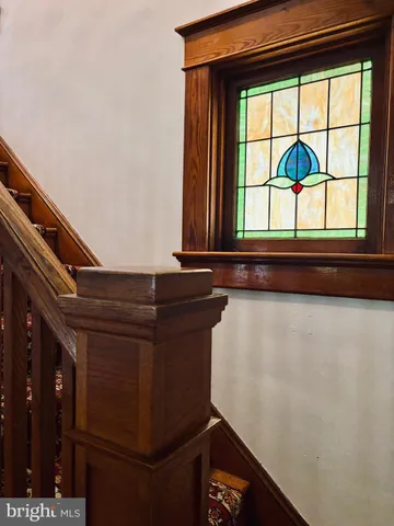 a view of an empty room with wooden floor and a ceiling fan