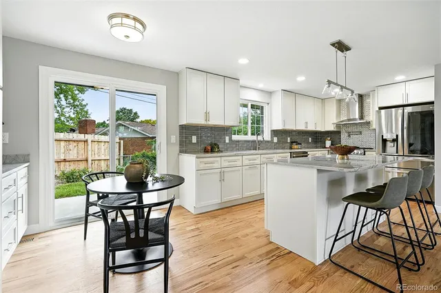 a kitchen with a table chairs refrigerator and cabinets
