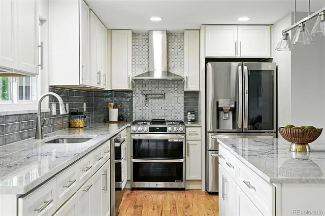 a kitchen with stainless steel appliances granite countertop a sink stove and refrigerator