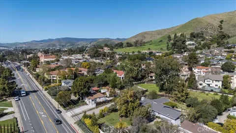 an aerial view of residential houses with outdoor space and trees