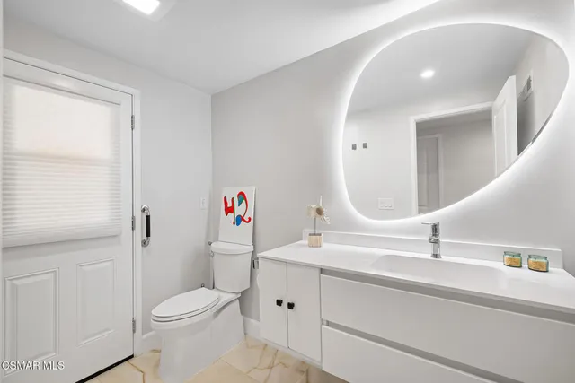 a bathroom with a sink a toilet and a mirror