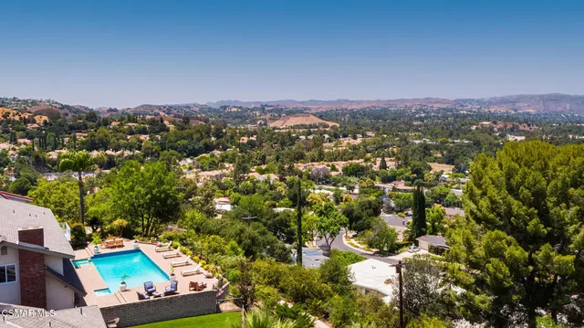 an aerial view of residential houses with outdoor space and trees