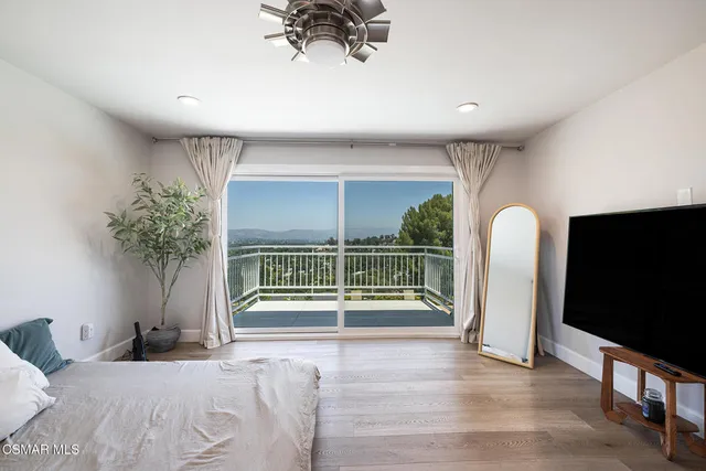 a bedroom with furniture and a large window