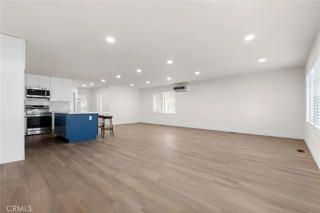 a view of kitchen and kitchen with stainless steel appliances wooden floor