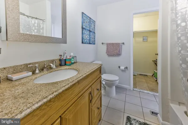 a bathroom with a granite countertop sink a toilet and a shower