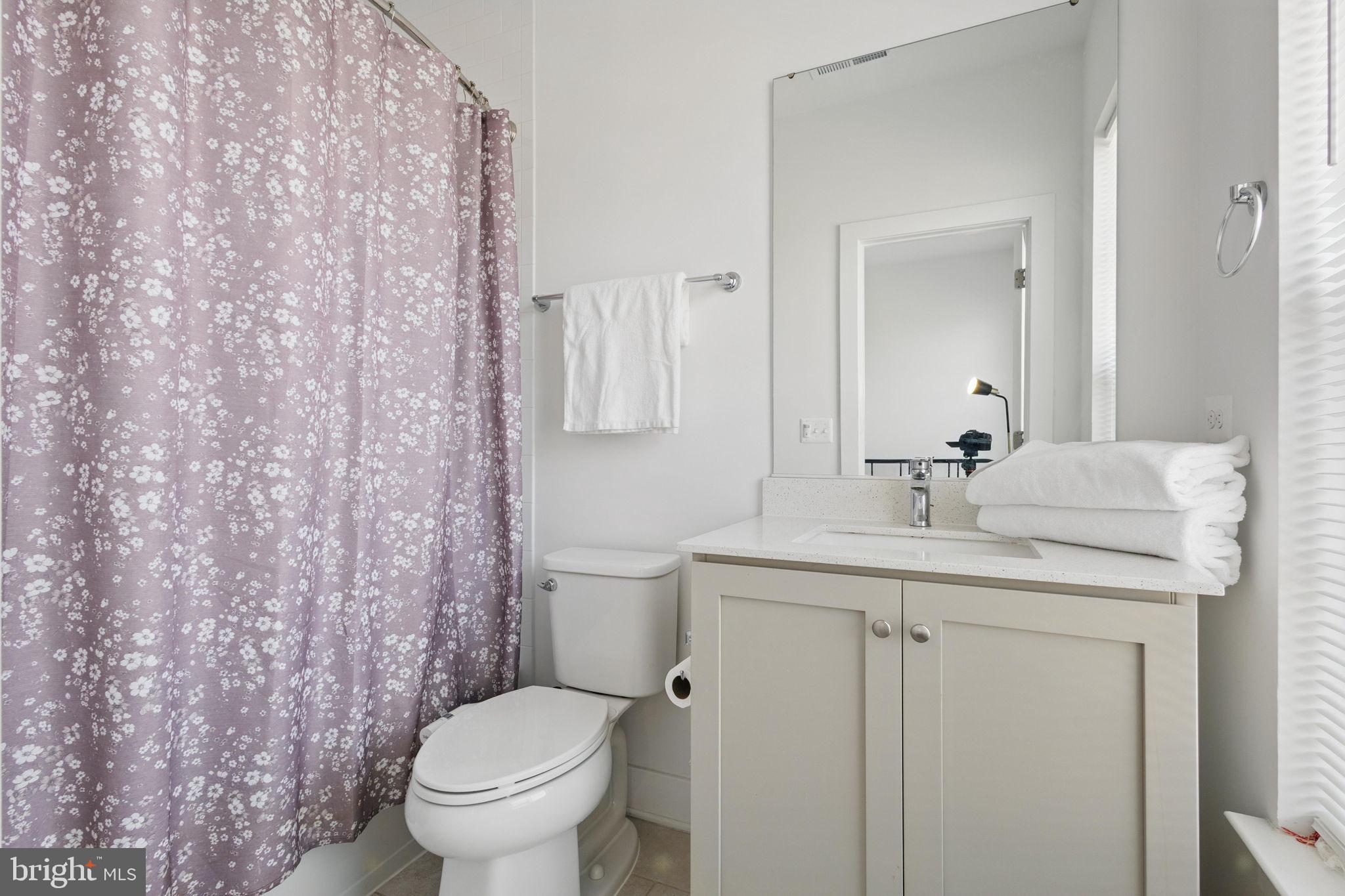11239 Beaker Street Reston, VA 20190 - Photo 16 of 22 a bathroom with a granite countertop sink toilet and a mirror