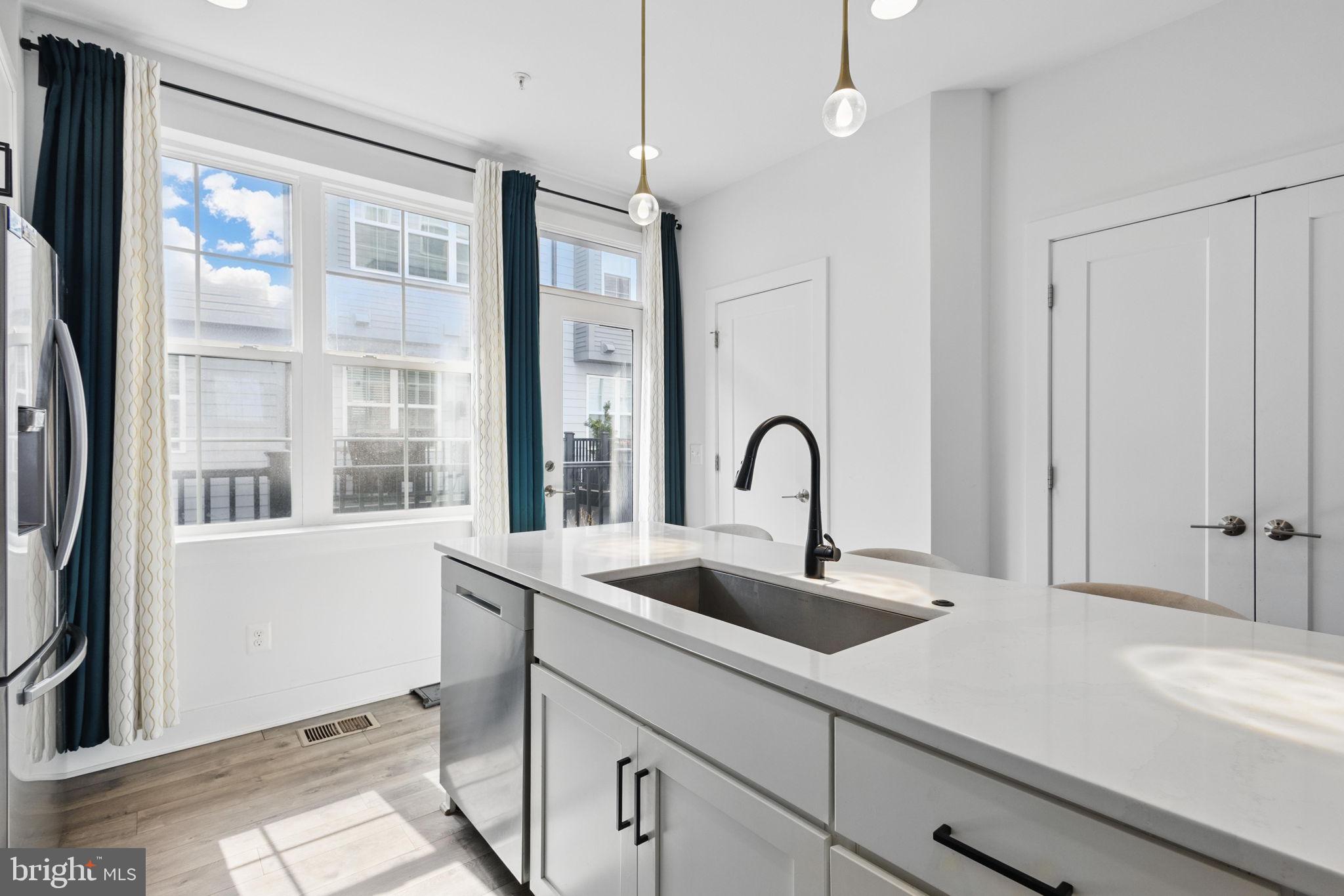 11239 Beaker Street Reston, VA 20190 - Photo 7 of 22 a kitchen with a sink and large windows