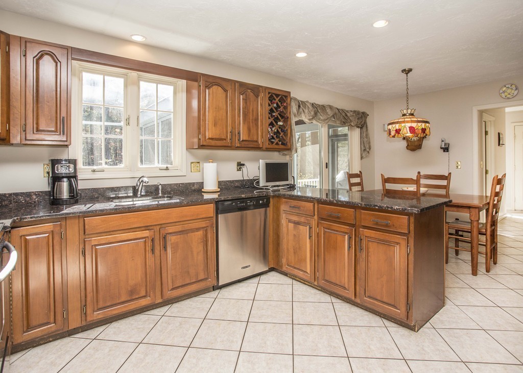 15 Virginia Ridge Road Sudbury, MA 01776 - Photo 3 of 16 a large kitchen with granite countertop a stove a sink and dishwasher wooden cabinets with granite countertops