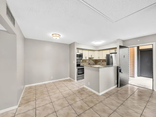 a kitchen with a refrigerator and white cabinets