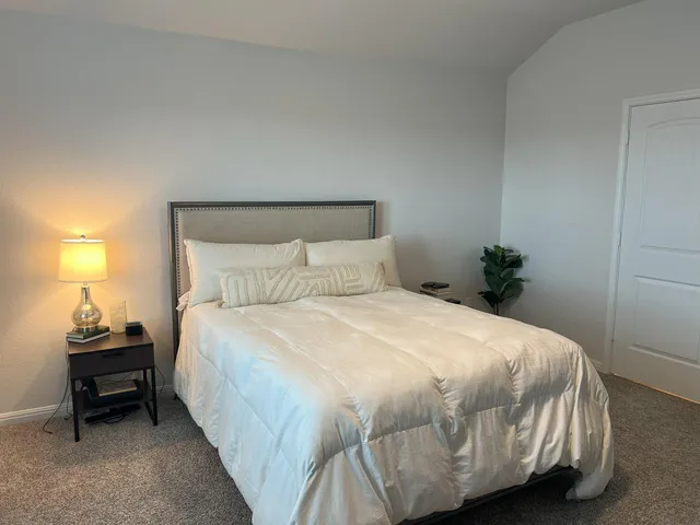 a bedroom with a bed and a lamp