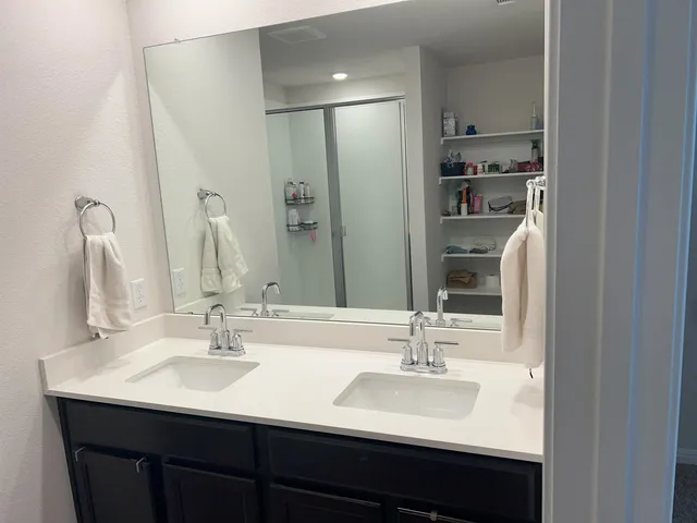 a bathroom with double vanity sinks and a mirror