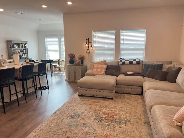 a living room with furniture wooden floor and a table