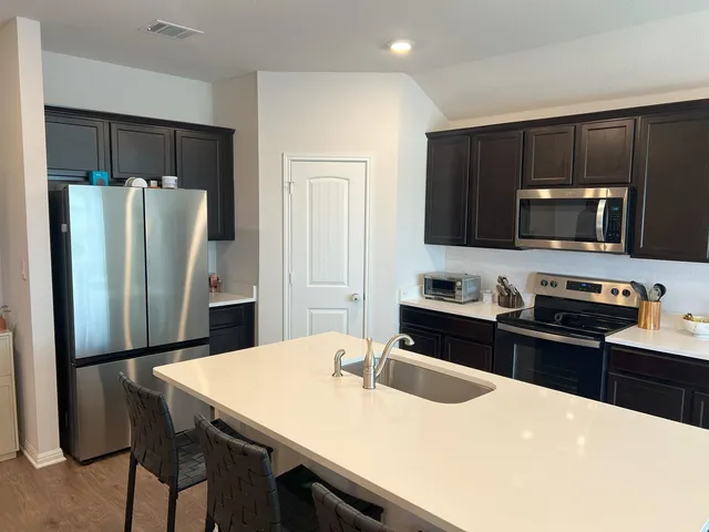 a kitchen with stainless steel appliances a refrigerator stove microwave and sink