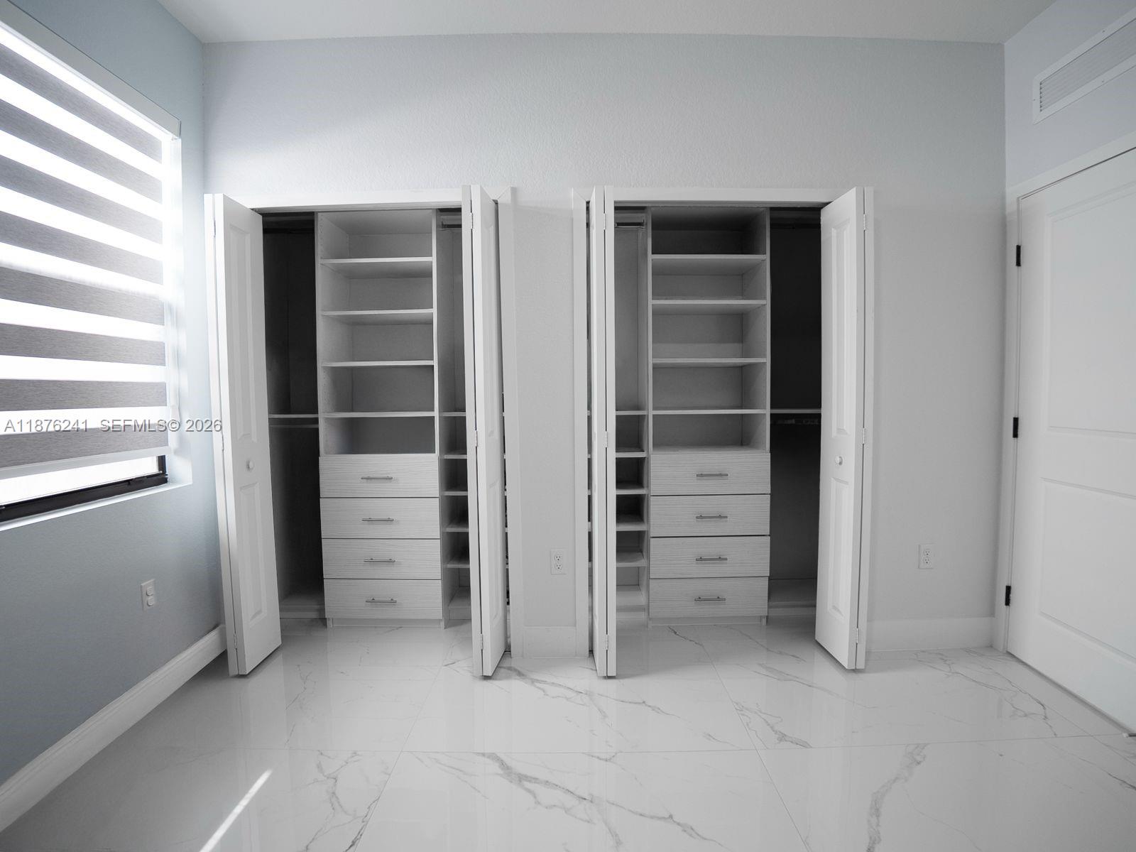 14478 Southwest 21st Street Miami, FL 33175 - Photo 16 of 42 a view of walk in closet with empty racks