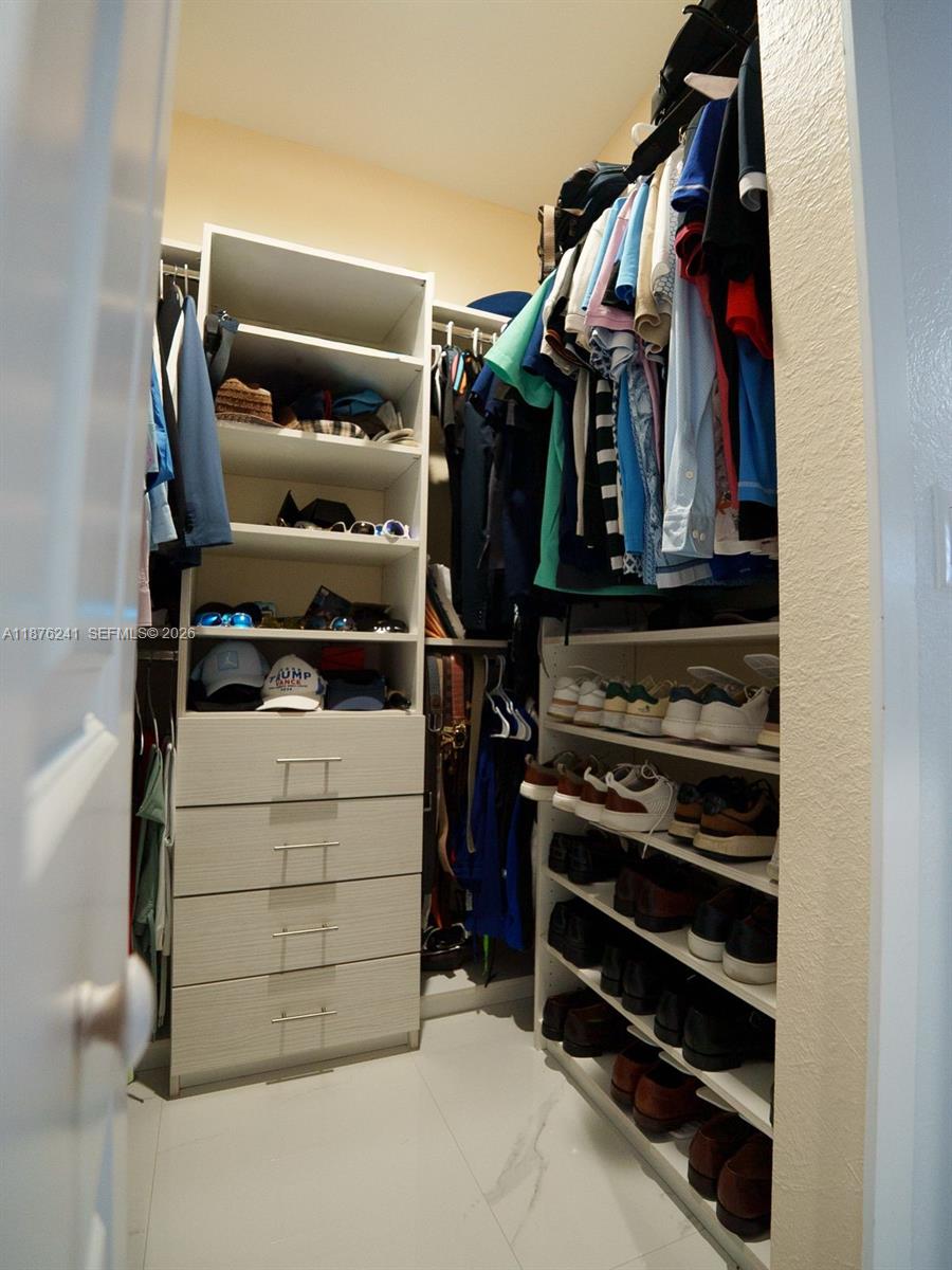 14478 Southwest 21st Street Miami, FL 33175 - Photo 26 of 42 a view of walk in closet with clothes and shoes