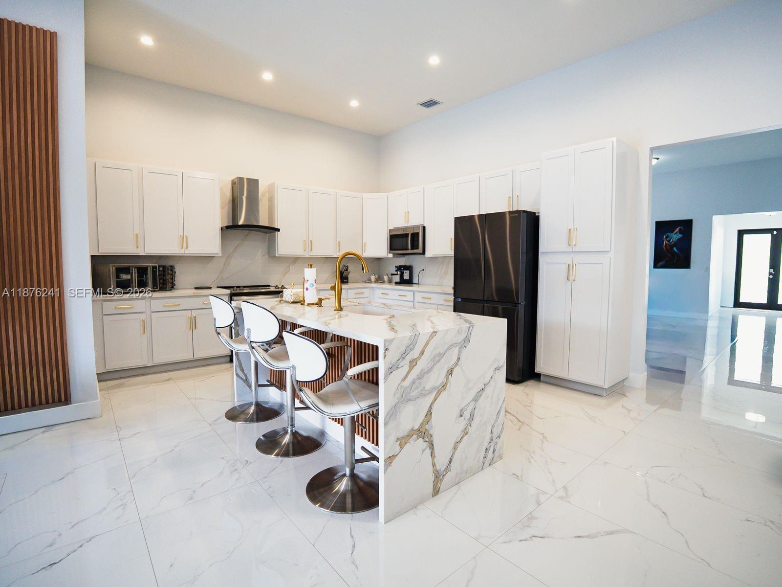 14478 Southwest 21st Street Miami, FL 33175 - Photo 3 of 42 a kitchen with stainless steel appliances kitchen island granite countertop a refrigerator and a stove top oven