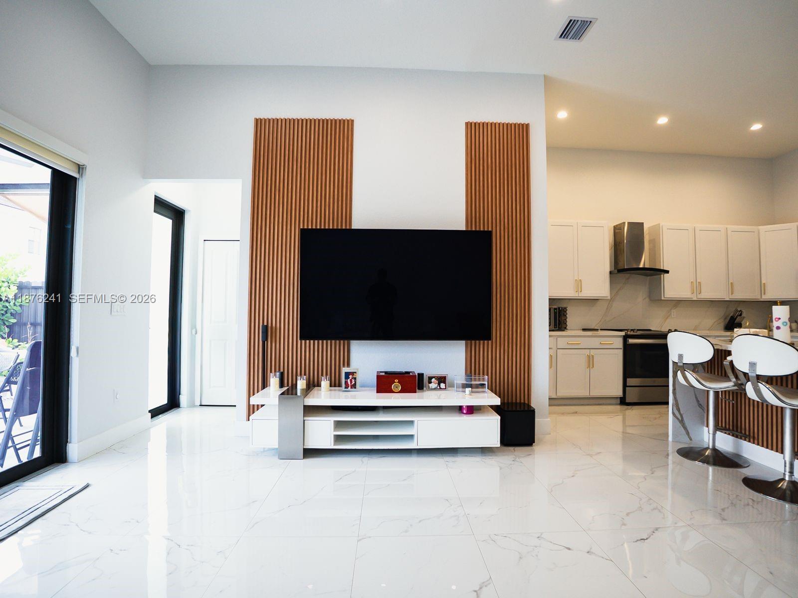 14478 Southwest 21st Street Miami, FL 33175 - Photo 32 of 42 a living room with furniture and a flat screen tv