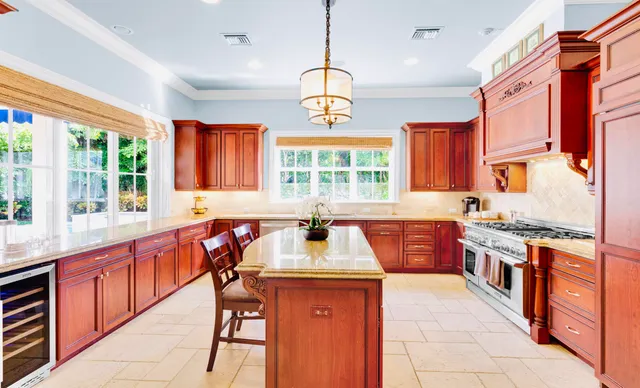 a kitchen with stainless steel appliances granite countertop a stove a sink dishwasher and a refrigerator with wooden floor