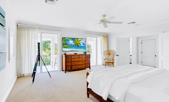 a spacious bedroom with a bed and a flat tv screen