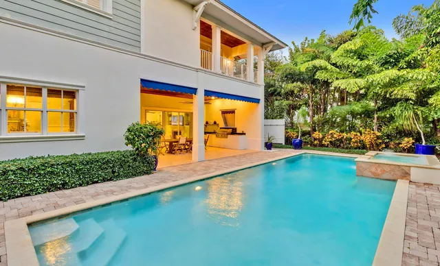 a view of a swimming pool with two chairs in a patio