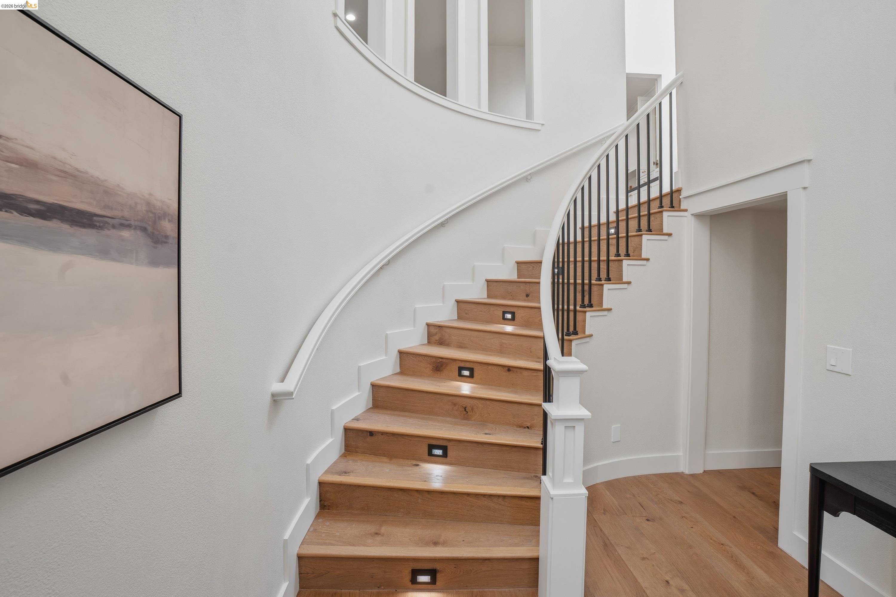 4120 Happy Valley Road Lafayette, CA 94549 - Photo 3 of 33 Curved staircase featuring wood-finish treads, black metal balusters, and white risers