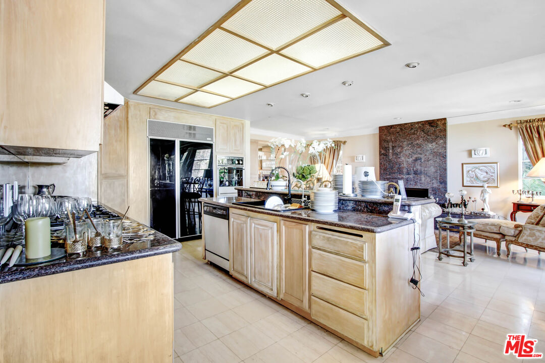 12535 Promontory Road Los Angeles, CA 90049 - Photo 12 of 42 a kitchen with stainless steel appliances granite countertop a sink and cabinets