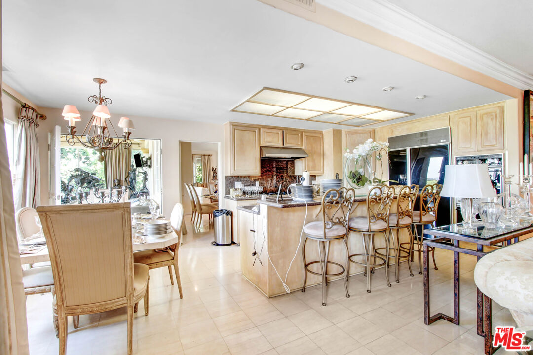 12535 Promontory Road Los Angeles, CA 90049 - Photo 17 of 42 a view of a dining room with furniture and chandelier