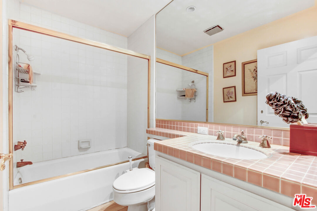 12535 Promontory Road Los Angeles, CA 90049 - Photo 20 of 42 a bathroom with a granite countertop sink a toilet and shower
