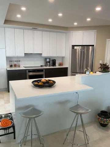 a kitchen with stainless steel appliances granite countertop a sink a stove a refrigerator and cabinets