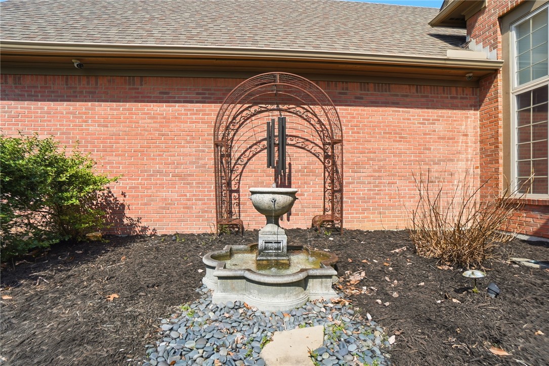 472 Timber Walk Court Springboro, OH 45066 - Photo 60 of 86 An inviting water feature and arched trellis adorn the brick exterior, complementing the landscaping.