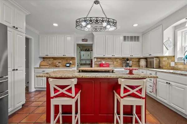 a kitchen with stainless steel appliances granite countertop a stove a sink dishwasher a microwave oven and a refrigerator with wooden cabinets