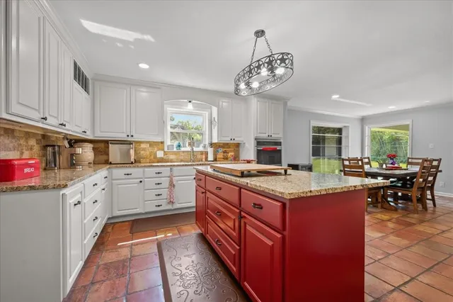 a kitchen with a stove top oven cabinets a dining table and chairs