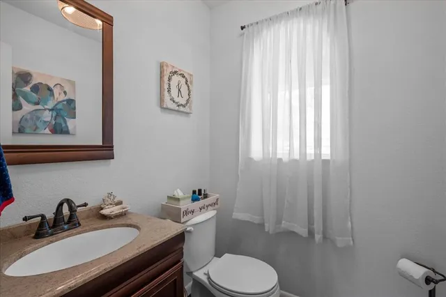 a bathroom with a sink vanity mirror and toilet