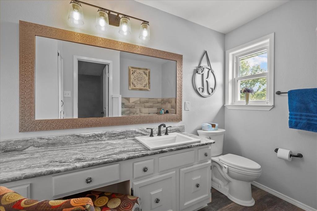 3400 Obrien Circle Waco, TX 76708 - Photo 28 of 36 a bathroom with a granite countertop sink a toilet and a mirror