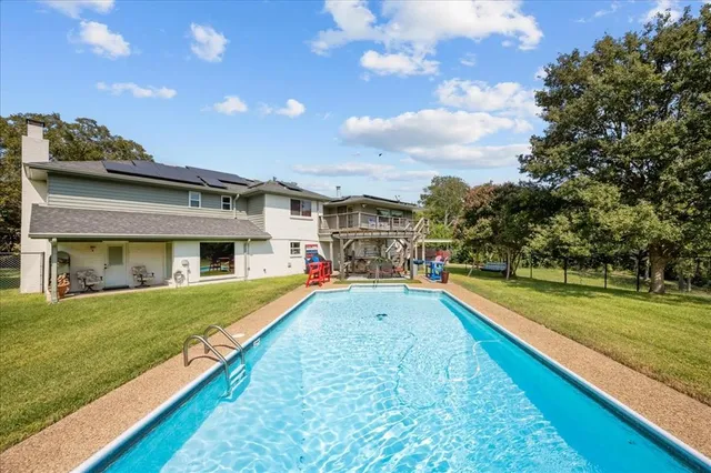 a view of a house with swimming pool and a yard