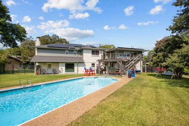 a view of a house with swimming pool and a yard