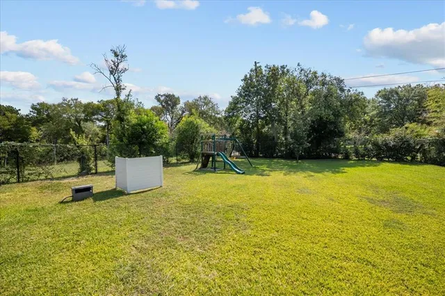 a house view with a play ground in front of it