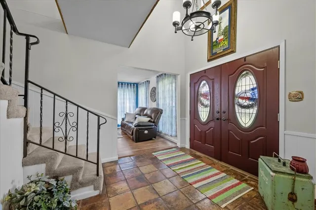 a view of staircase with a table and a chandelier